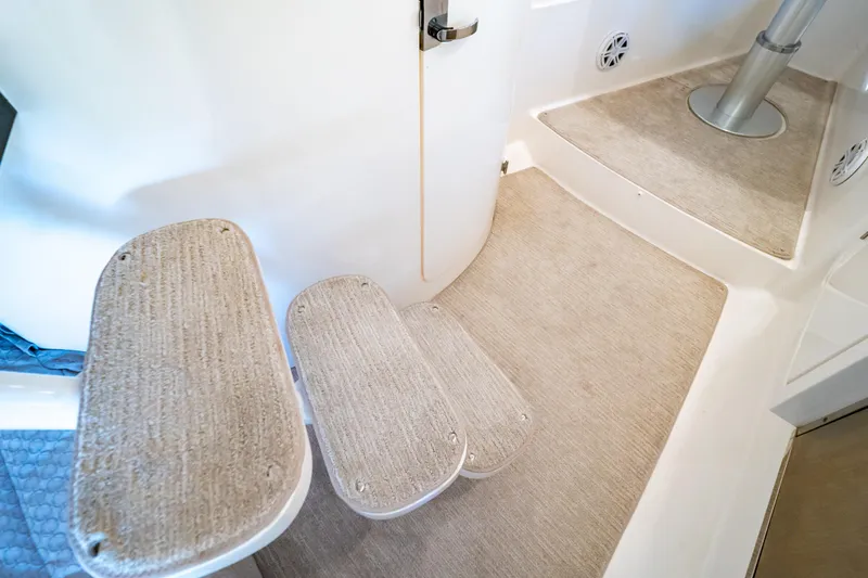 Slide: The Image of Interior steps of a 2016 Intrepid 400 Cuddy boat, featuring carpeted surfaces. - 63