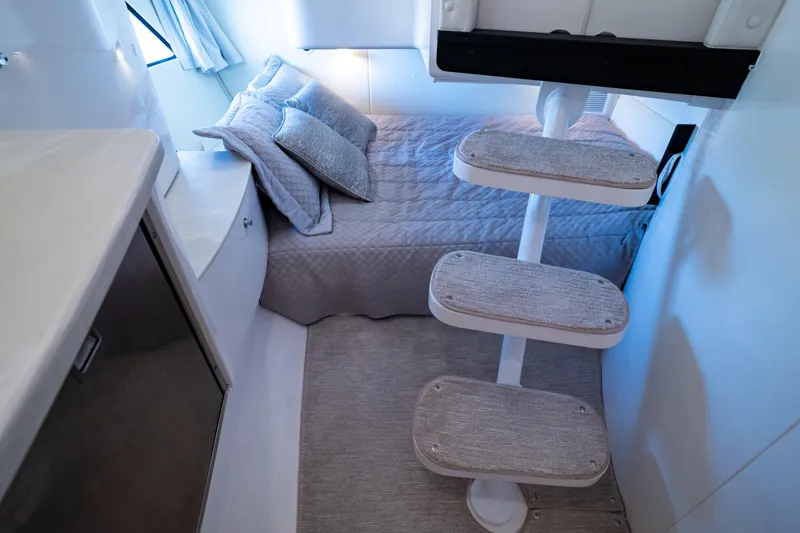 Slide: The Image of Interior of 2016 Intrepid 400 Cuddy, featuring cozy bed and compact staircase. - 7