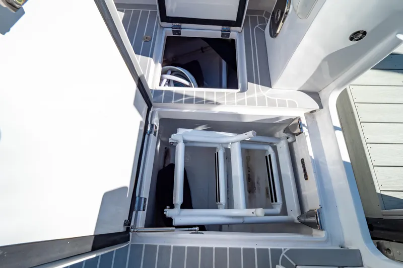 Slide: The Image of Open storage compartments on a 2016 Intrepid 400 Cuddy boat deck. - 77