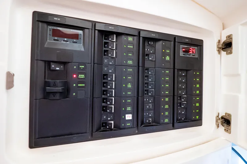 Slide: The Image of Electrical panel on a 2016 Intrepid 400 Cuddy boat, showcasing circuit breakers and digital displays. - 85