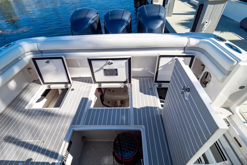 Slide: The Image of 2016 Intrepid 400 Cuddy boat deck with open storage compartments and triple engines. - 98