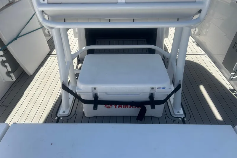 Slide: The Image of 2024 Yamaha Boats 252 FSH Sport deck with cooler and seating area. - 11