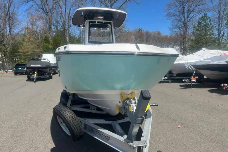 Slide: The Image of 2024 Yamaha Boats 252 FSH Sport on trailer, parked outdoors, front view. - 2