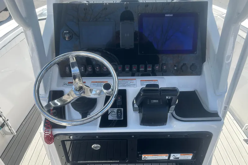 Slide: The Image of 2024 Yamaha Boats 252 FSH Sport dashboard with steering wheel and controls. - 8