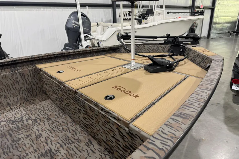 Slide: The Image of 2025 Xpress H190B Bay boat with Seadek flooring and Yamaha motor in a showroom. - 2