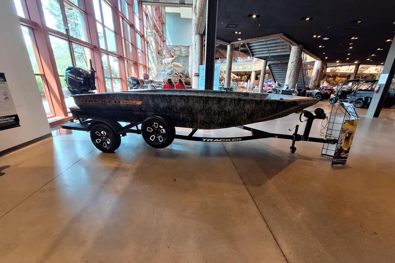 The Image of 2026 Tracker Grizzly 1756 T Marsh boat displayed indoors on a trailer. - 0