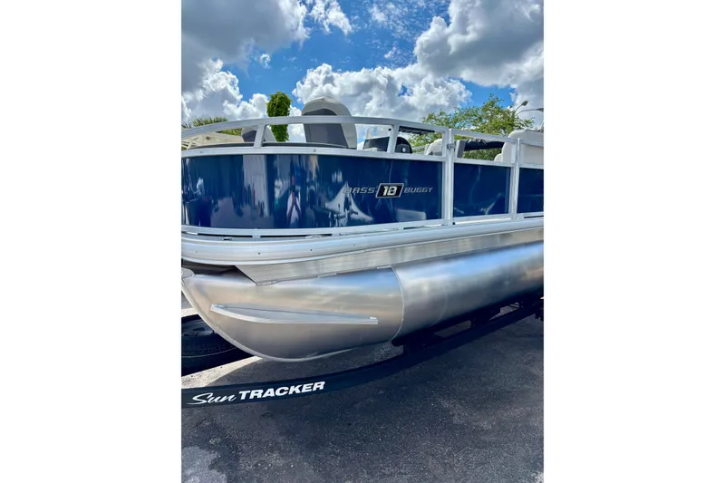 The Image of 2026 Sun Tracker Bass Buggy 18 DLX pontoon boat under a partly cloudy sky. - 0
