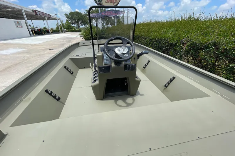 Slide: The Image of 2026 Tracker Grizzly 2072 CC boat interior with steering console, parked outdoors. - 45
