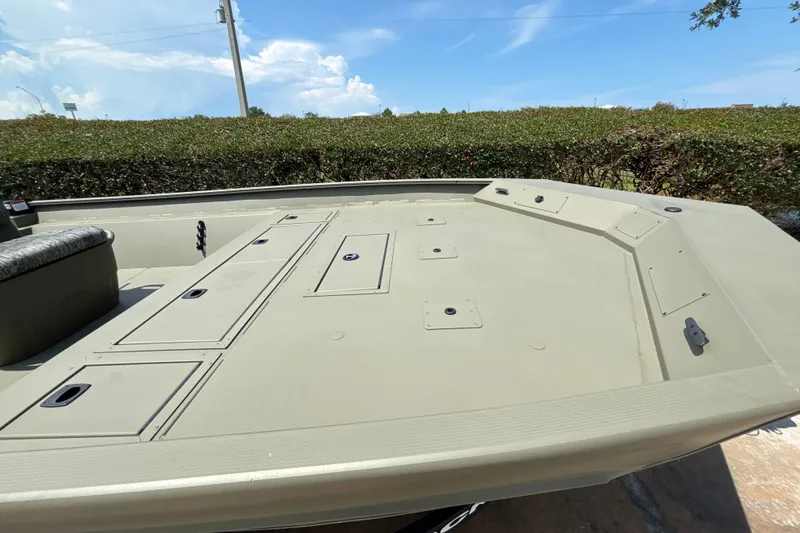 Slide: The Image of 2026 Tracker Grizzly 2072 CC boat deck with storage compartments under a clear blue sky. - 14
