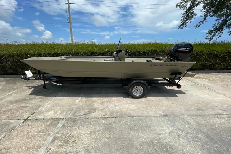 Slide: The Image of 2026 Tracker Grizzly 2072 CC boat on trailer, parked outdoors under a clear sky. - 37