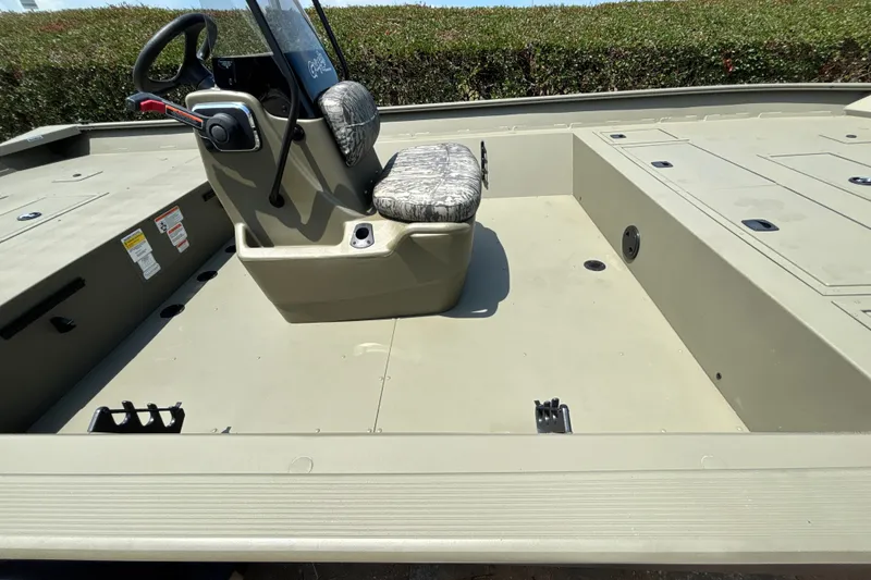 Slide: The Image of 2026 Tracker Grizzly 2072 CC boat interior with steering console and cushioned seat. - 15
