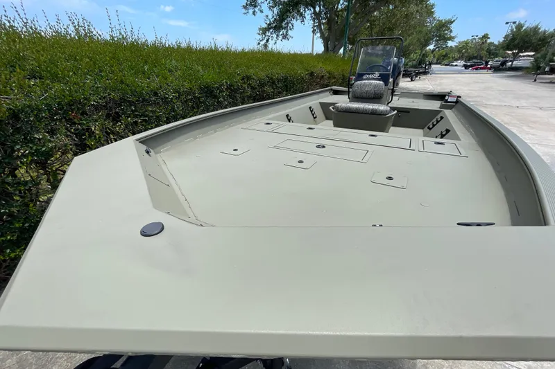 Slide: The Image of 2026 Tracker Grizzly 2072 CC boat with spacious deck and seating, parked outdoors. - 44