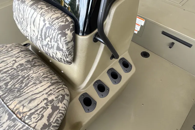 Slide: The Image of 2026 Tracker Grizzly 2072 CC boat interior with camo seating and rod holders. - 24