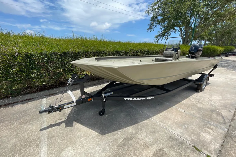 Slide: The Image of 2026 Tracker Grizzly 2072 CC boat on trailer, parked outdoors under blue sky. - 39