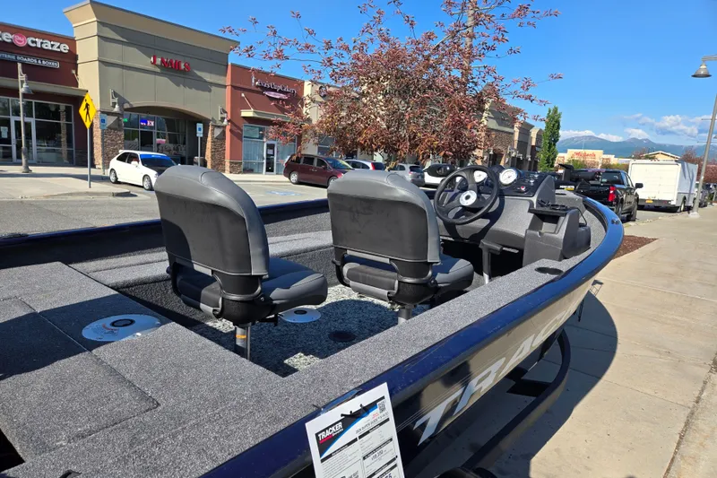 Slide: The Image of 2026 Tracker Super Guide V-16 SC boat displayed outdoors near shops. - 5
