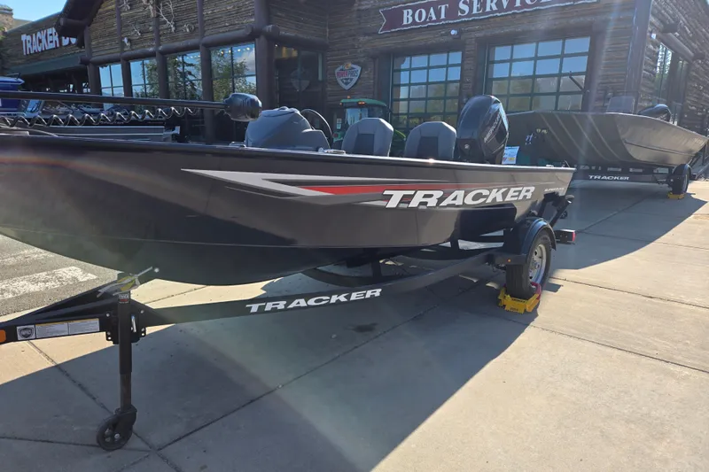 Slide: The Image of 2026 Tracker Super Guide V-16 SC boat displayed at a boat service center. - 2