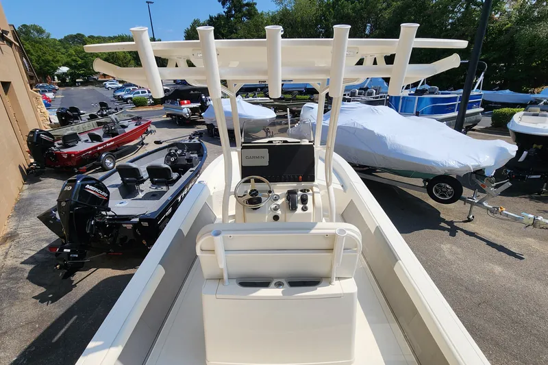 Slide: The Image of 2026 Mako 24 APEX boat with Garmin navigation, parked among other boats. - 2