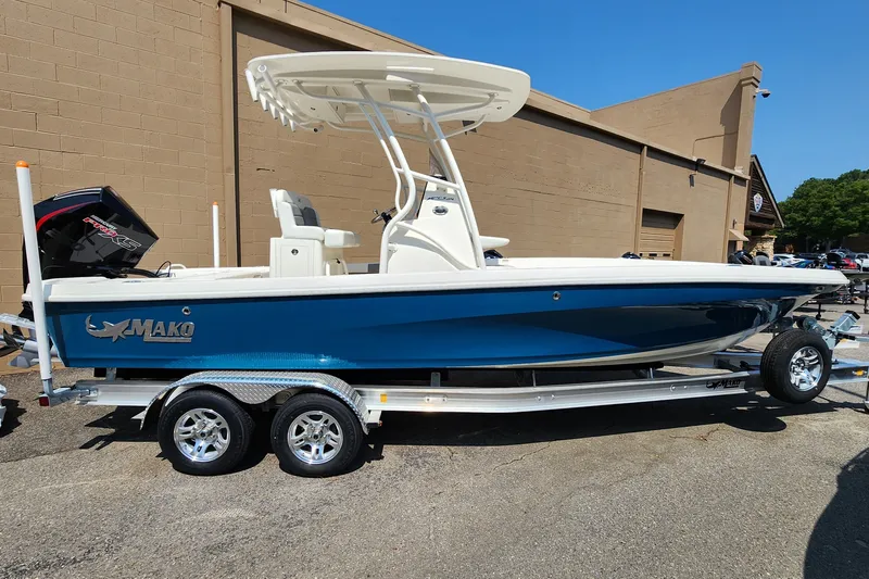 The Image of 2026 Mako 24 APEX boat on trailer, blue hull, parked outdoors. - 0