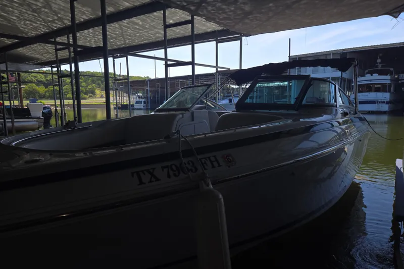 Slide: The Image of 2001 Cobalt 292 boat docked in a marina, partially shaded, with surrounding water and boats. - 3