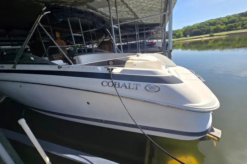 Slide: The Image of 2001 Cobalt 292 boat docked on calm water under a covered marina. - 5