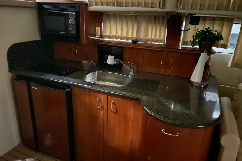 Slide: The Image of Luxurious kitchen area in a 2004 Carver 420 Mariner yacht with wood cabinetry and granite countertops. - 10