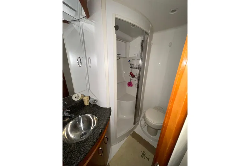 Slide: The Image of Bathroom interior of 2004 Carver 420 Mariner yacht, featuring sink, shower, and toilet. - 14