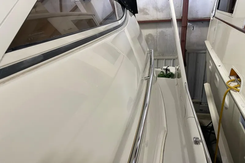 Slide: The Image of 2004 Carver 420 Mariner yacht in storage, showcasing sleek exterior design and polished railings. - 22