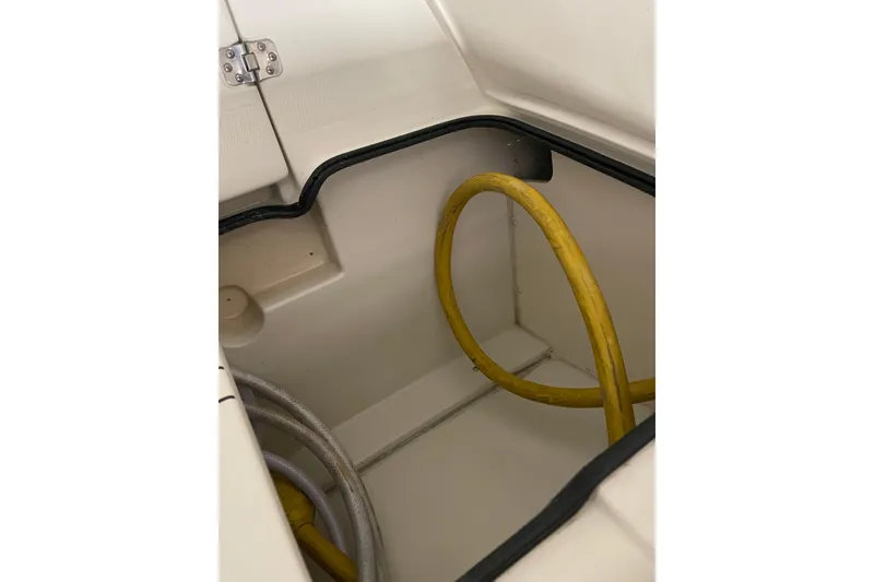 Slide: The Image of Storage compartment with yellow hose on 2004 Carver 420 Mariner boat. - 24