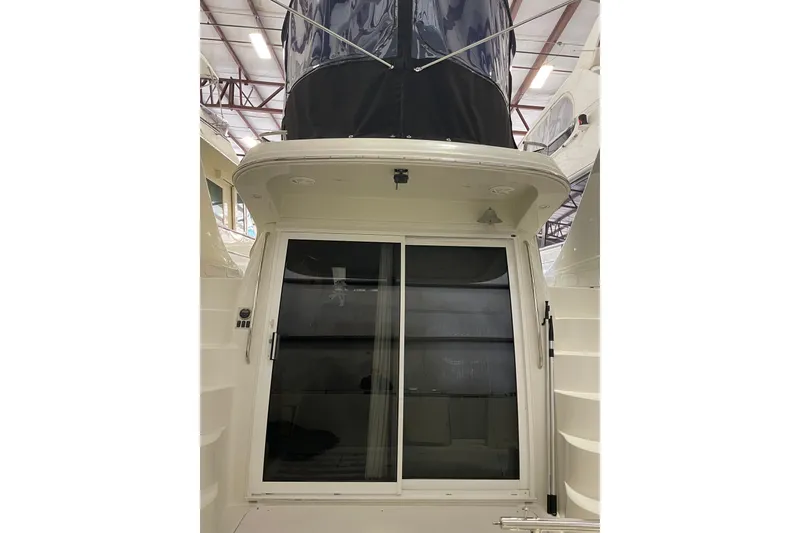 Slide: The Image of 2004 Carver 420 Mariner yacht with sliding glass doors in a marina setting. - 4