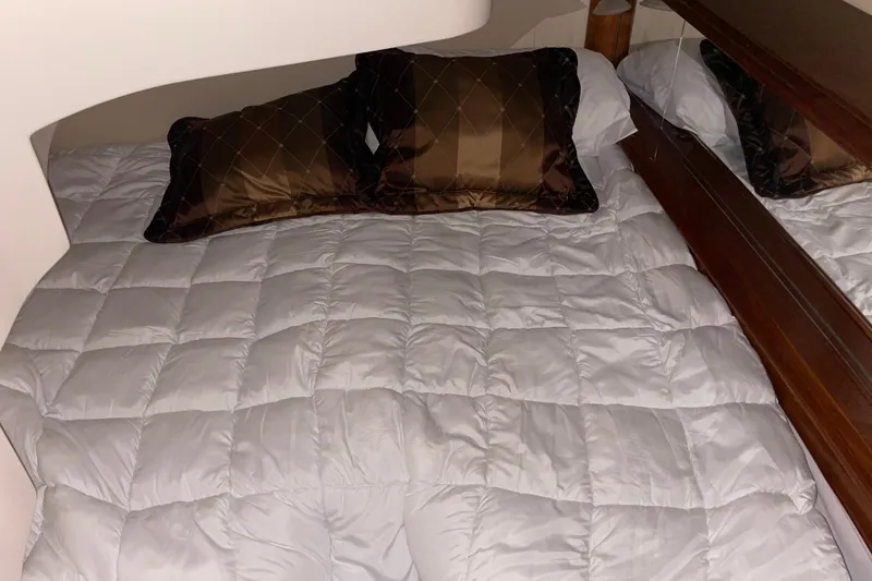 Slide: The Image of Cozy bed with white quilt and brown pillows in 2004 Carver 420 Mariner yacht cabin. - 8