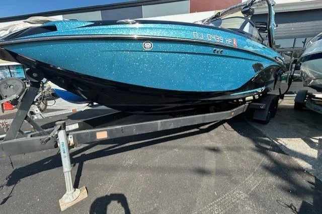 The Image of 2020 Centurion Ri237 boat in blue and black on a trailer outside a dealership. - 0