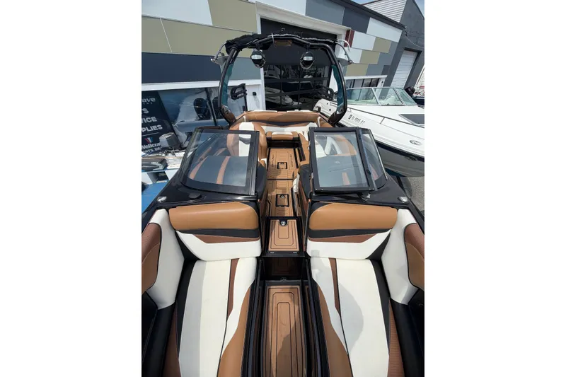 Slide: The Image of 2020 Centurion Ri237 boat interior with luxurious brown and white seating, open windshield. - 16