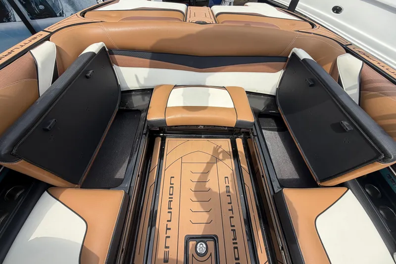 Slide: The Image of 2020 Centurion Ri237 boat interior with tan and white seating, open storage compartments. - 19
