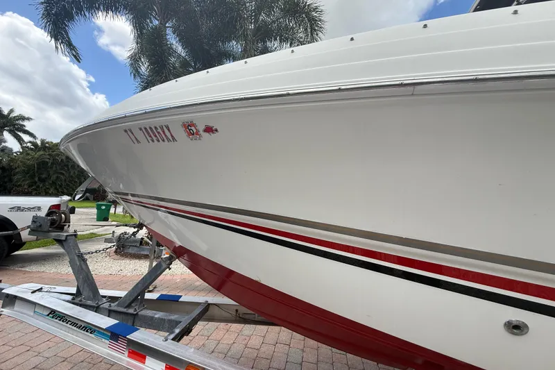 Slide: The Image of 2001 Wellcraft 29 Scarab Sport Open boat on trailer, palm trees in background. - 10