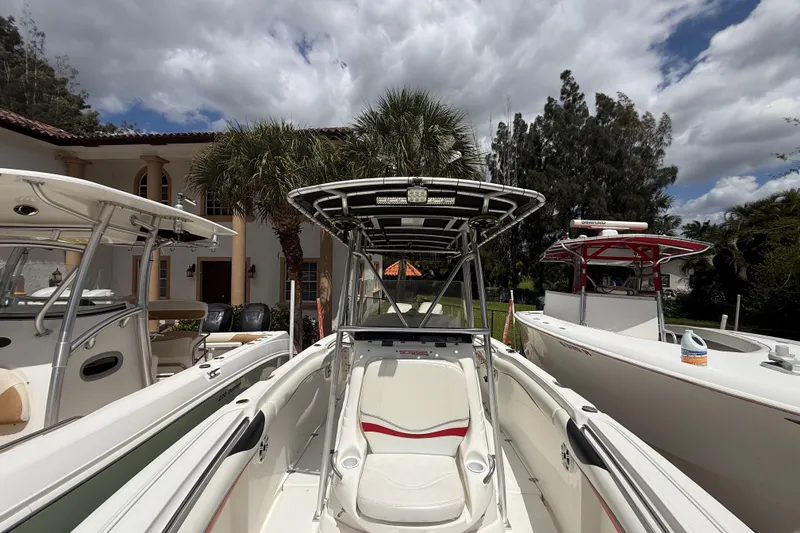 Slide: The Image of 2001 Wellcraft 29 Scarab Sport Open boat docked near palm trees and a house. - 100