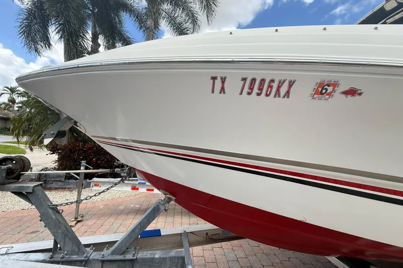 Slide: The Image of 2001 Wellcraft 29 Scarab Sport Open boat on trailer, displaying registration number TX 7996KX. - 11