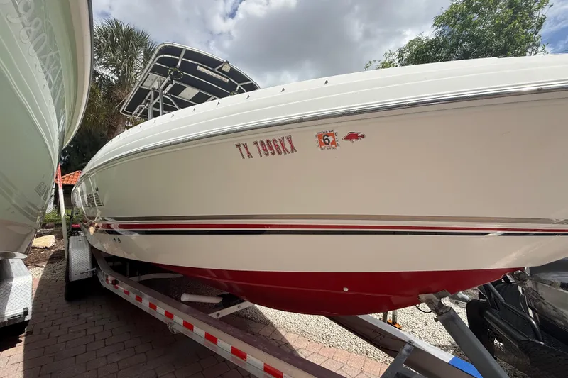 Slide: The Image of 2001 Wellcraft 29 Scarab Sport Open boat on trailer, white with red accents. - 18