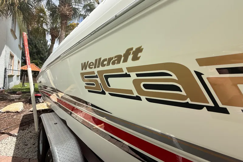Slide: The Image of 2001 Wellcraft 29 Scarab Sport Open boat side view with logo and trailer. - 21