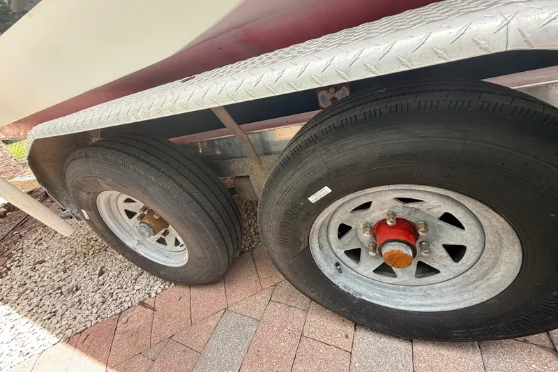 Slide: The Image of Trailer wheels of a 2001 Wellcraft 29 Scarab Sport Open boat on a paved surface. - 22