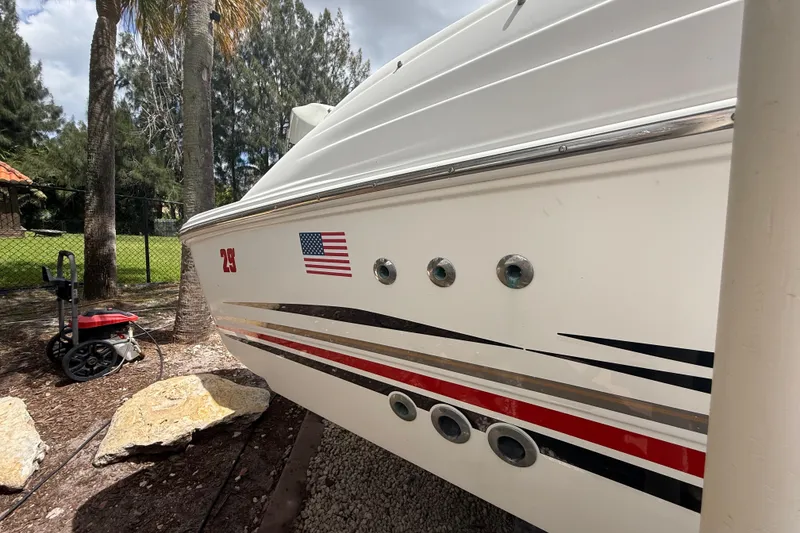 Slide: The Image of 2001 Wellcraft 29 Scarab Sport Open boat with American flag and sleek design. - 25