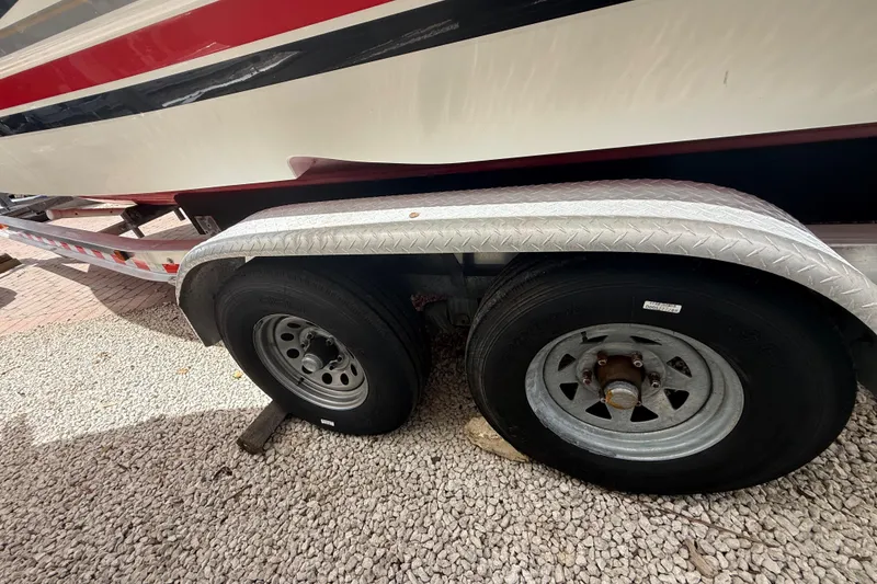 Slide: The Image of Trailer wheels of a 2001 Wellcraft 29 Scarab Sport Open boat on gravel. - 26