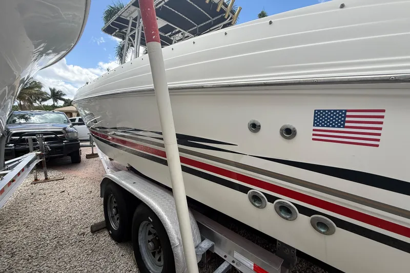 Slide: The Image of 2001 Wellcraft 29 Scarab Sport Open boat on trailer, American flag decal visible. - 4
