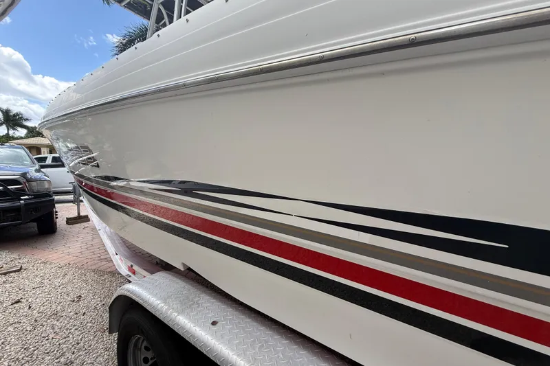 Slide: The Image of 2001 Wellcraft 29 Scarab Sport Open boat on trailer, side view with striped design. - 5