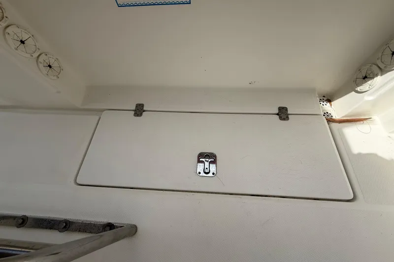 Slide: The Image of Hatch cover on 2001 Wellcraft 29 Scarab Sport Open boat, featuring metal hinges and latch. - 52