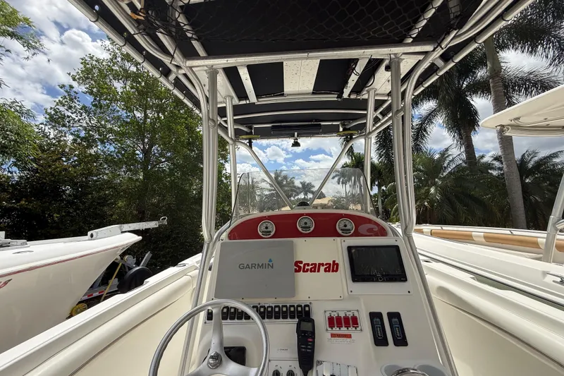 Slide: The Image of 2001 Wellcraft 29 Scarab Sport Open boat dashboard with Garmin navigation, surrounded by palm trees. - 66