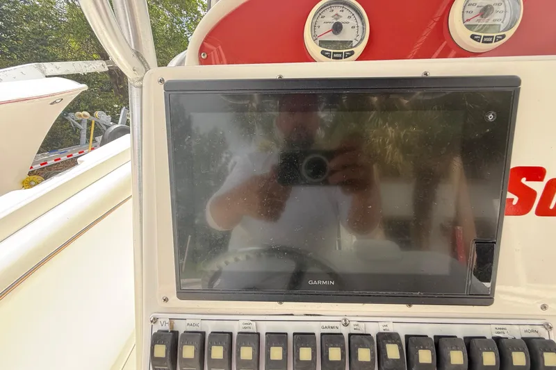 Slide: The Image of Console of a 2001 Wellcraft 29 Scarab Sport Open with Garmin display and switches. - 67