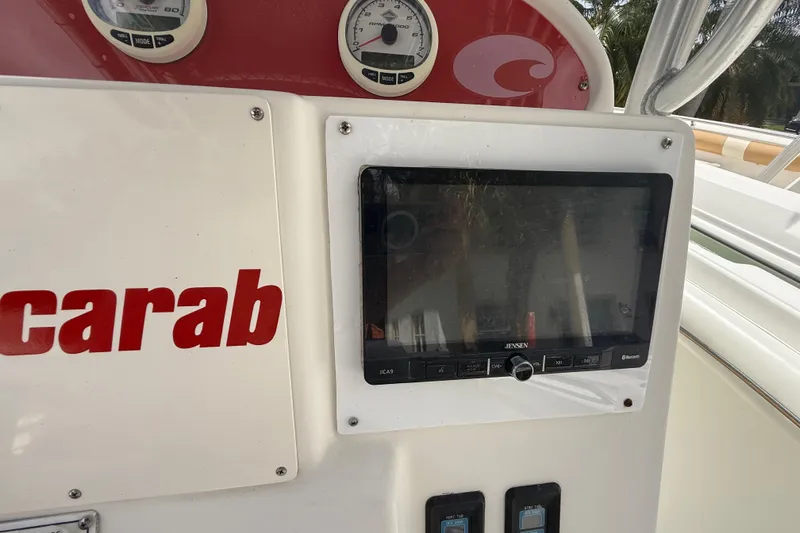 Slide: The Image of Console of 2001 Wellcraft 29 Scarab Sport Open with gauges and Jensen display. - 68