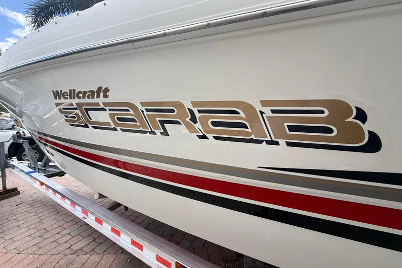 Slide: The Image of 2001 Wellcraft 29 Scarab Sport Open boat with bold logo and sleek design. - 7