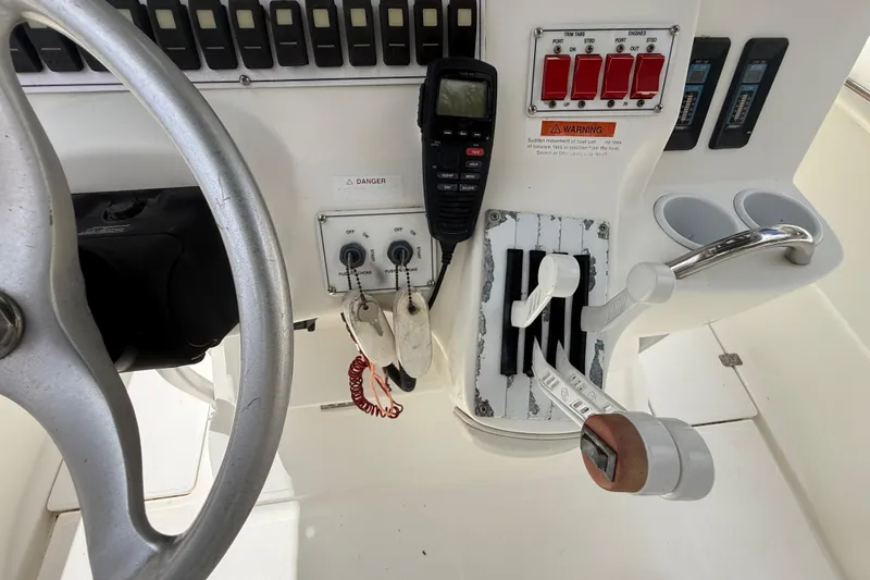 Slide: The Image of Control panel of a 2001 Wellcraft 29 Scarab Sport Open boat, featuring steering wheel and switches. - 72