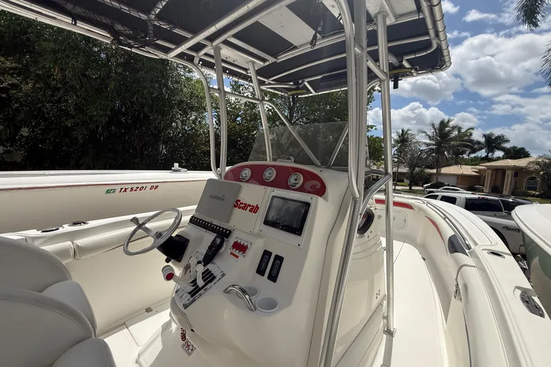 Slide: The Image of 2001 Wellcraft 29 Scarab Sport Open boat cockpit with steering wheel and navigation controls. - 74